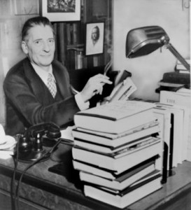 literary agent at desk with piles of books