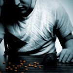 Depressed man at tables with pills Depressed man at tables with pills