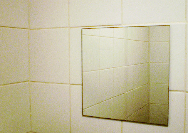 small square mirror in tiled bathroom 
