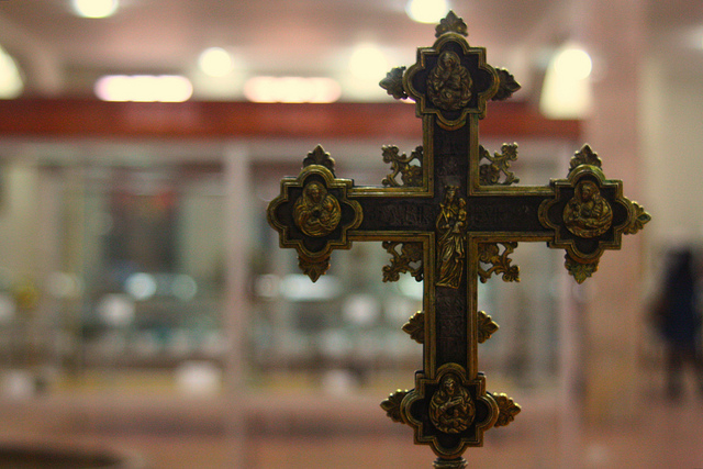 cross with church blurry in back