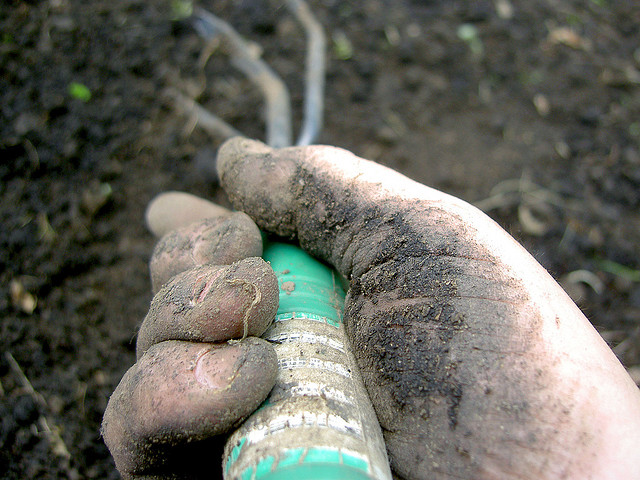 close up of hand on hoe in garden