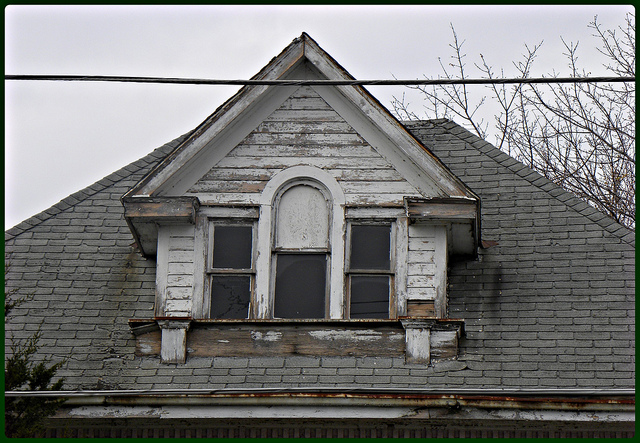 looking up at attic window of old house