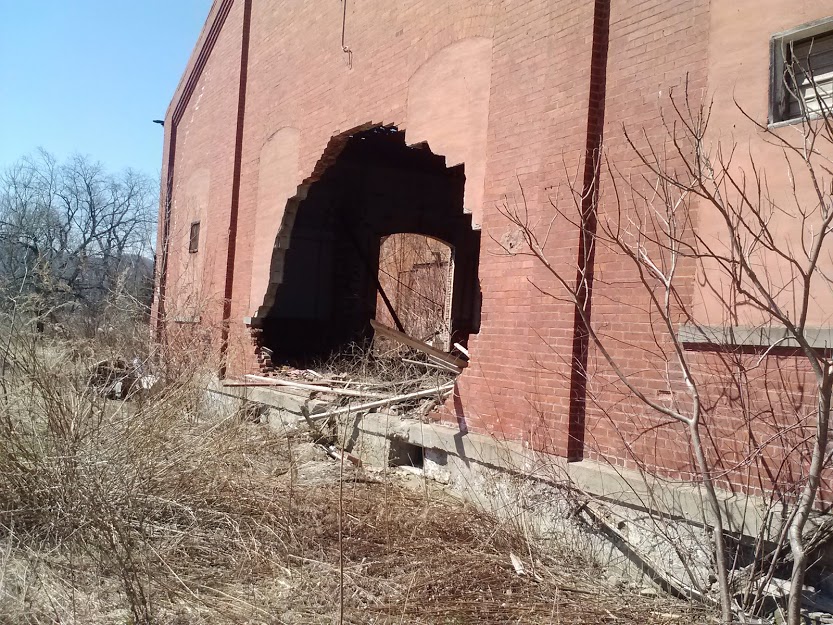 hole in brick wall in large building