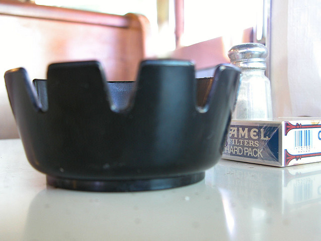 ash tray and pack of Camel cigarettes on diner table with salt and paper in background