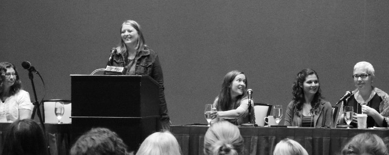 writers at a head table woman at podium