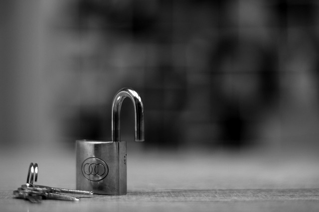 a padlock with two keys laying on one side of frame on table