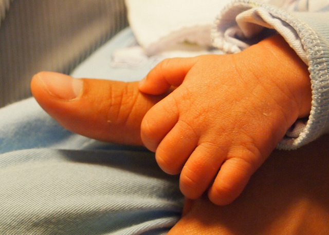 baby hand on a parent's thumb