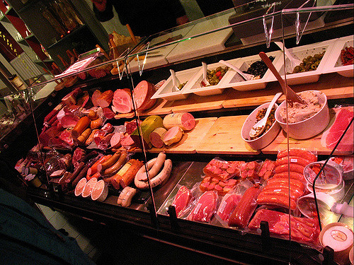 shot of butcher case with various meats and salads