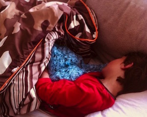 little boy with his blabket on couch
