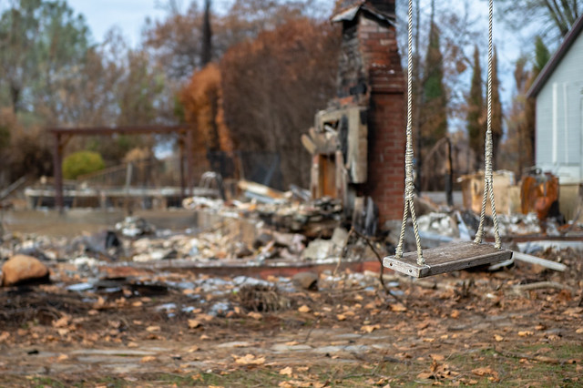 park damaged by fired, debris everywhere, but swing still in tact