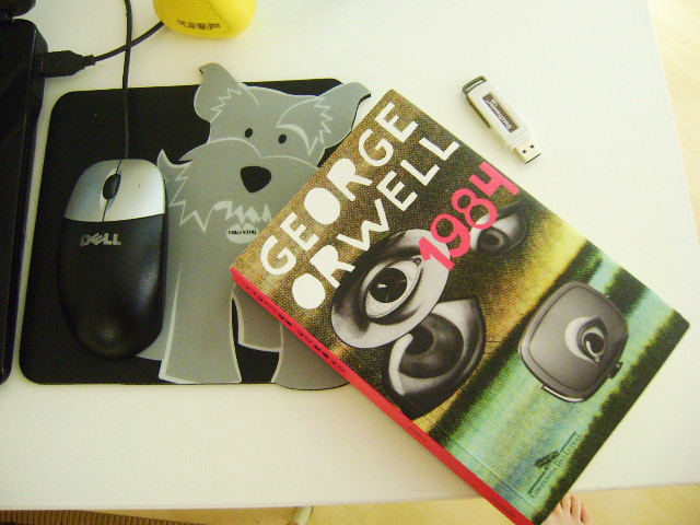 copy of 1985 novel on a desk by Dell mouse with a irish terrir mousepad; thumb drive next to it