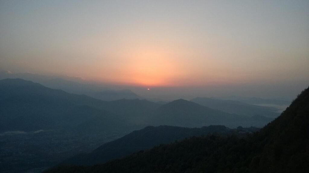 sunset at horizon over mountains