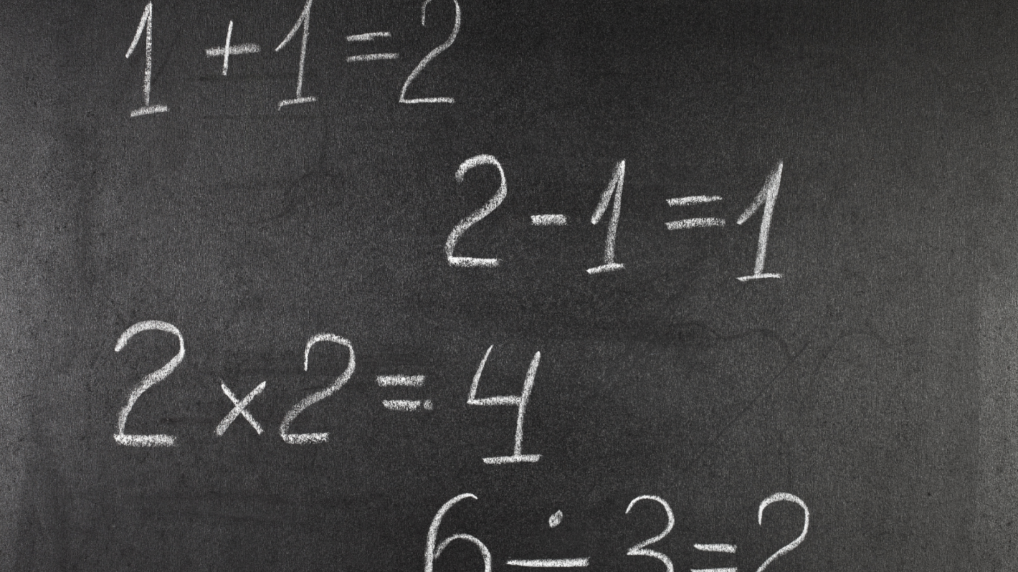 simple math equations in white chalk on a blackboard