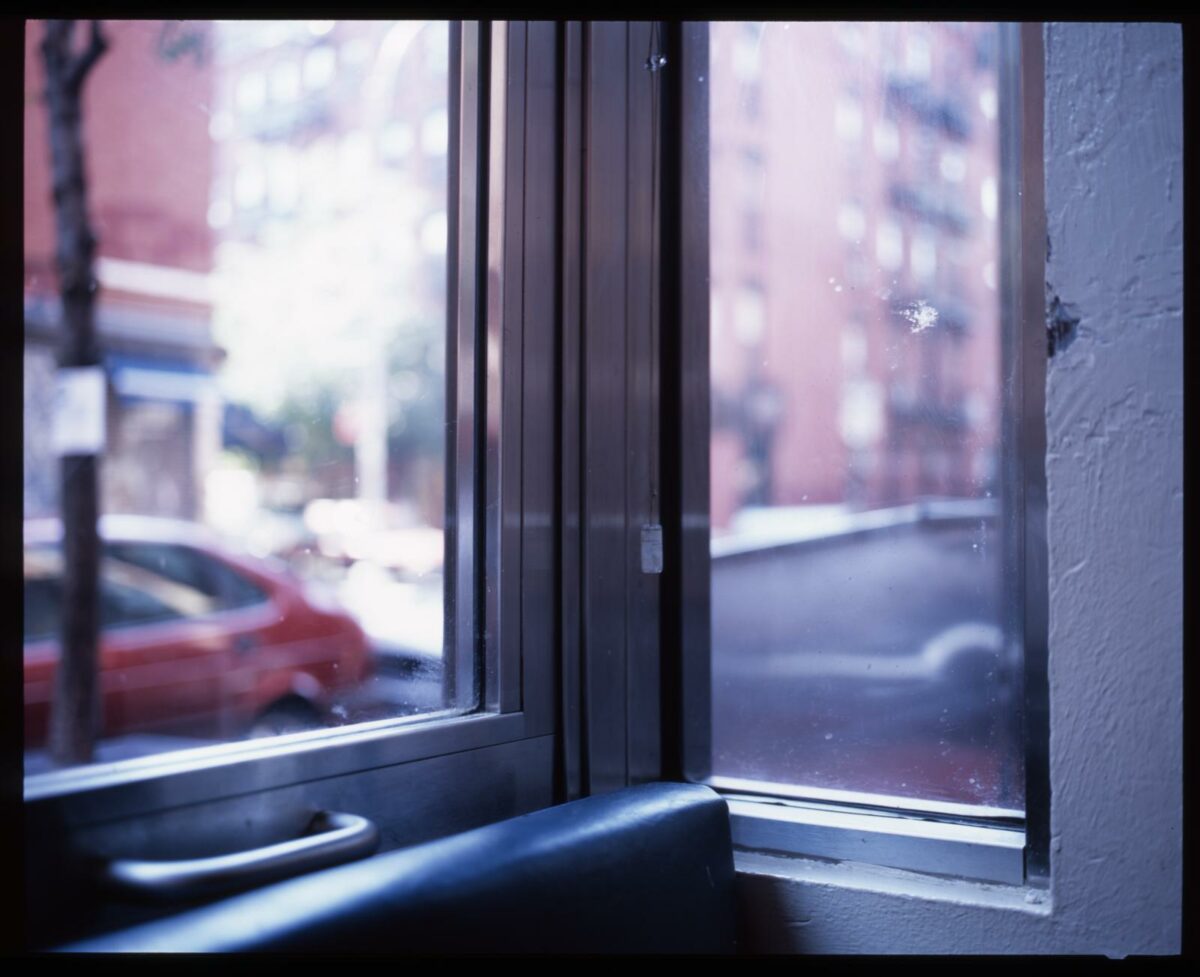 looking outside of a booth window onto a city street