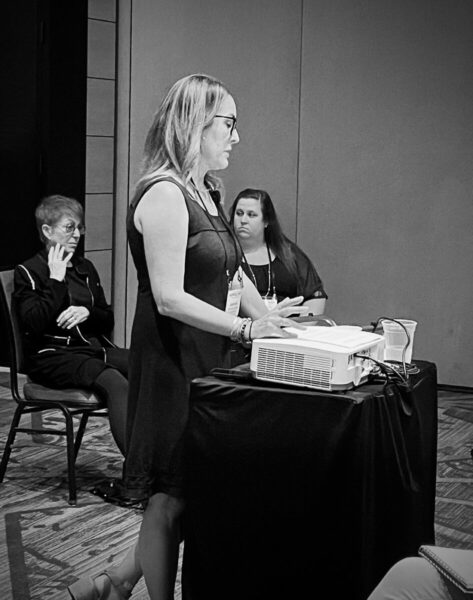 jeannine ouellette presenting about child narrators at HippoCamp 2022 with ASL interpreters behind her