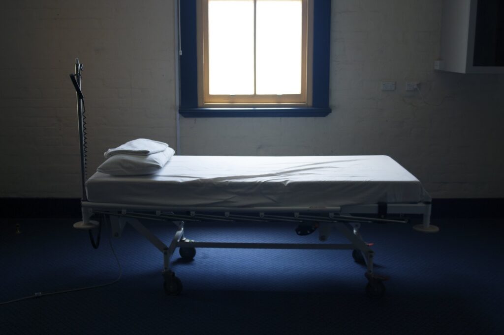 empty hospital cot in bare room