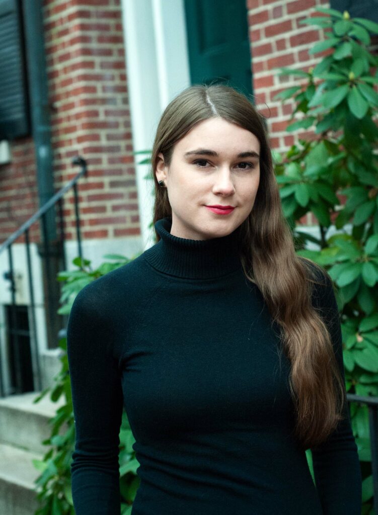 Author Rachel Reeker has long brown hair and is wearing a black sweater.