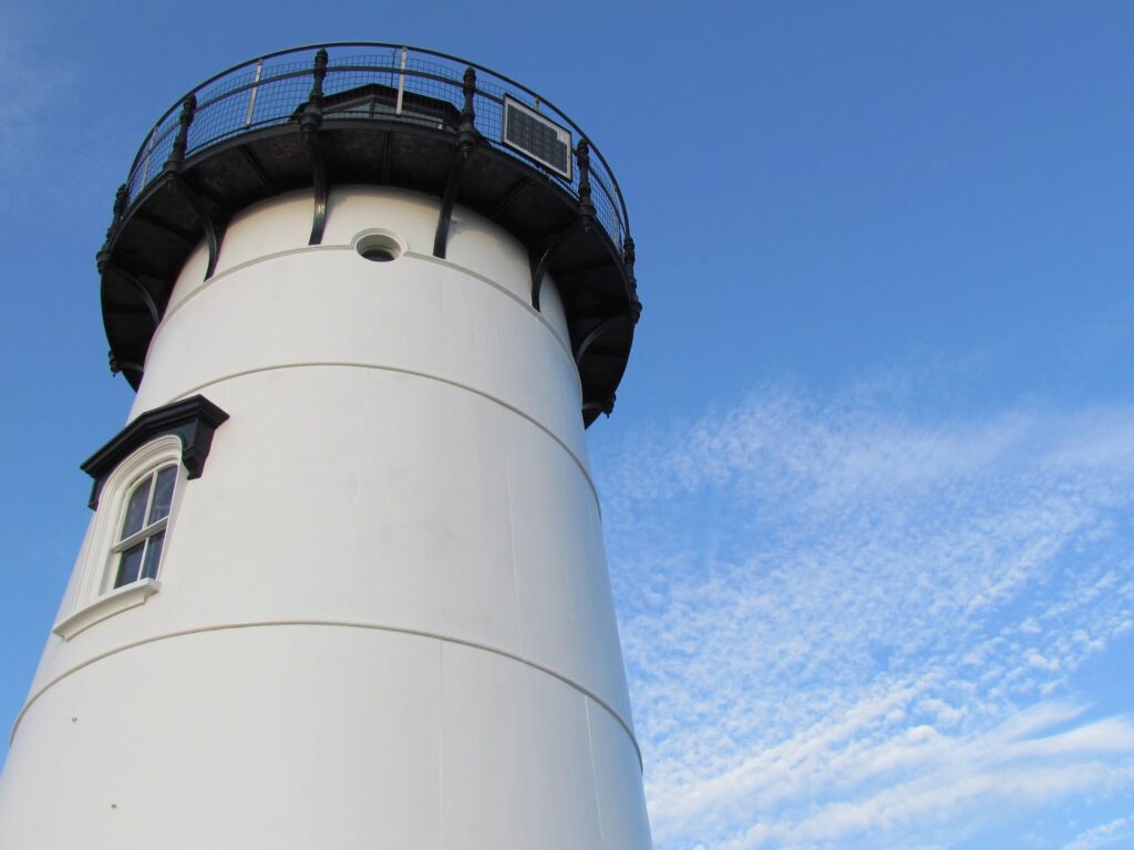 white lighthouse, taken from below looking up at clear blue sky