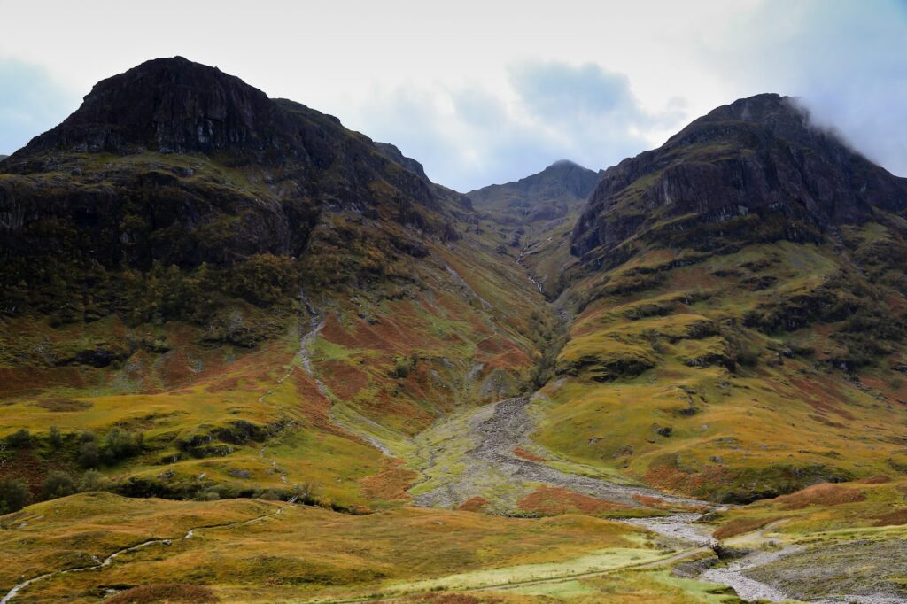 Mountains covered in greenish-orange moss and flora