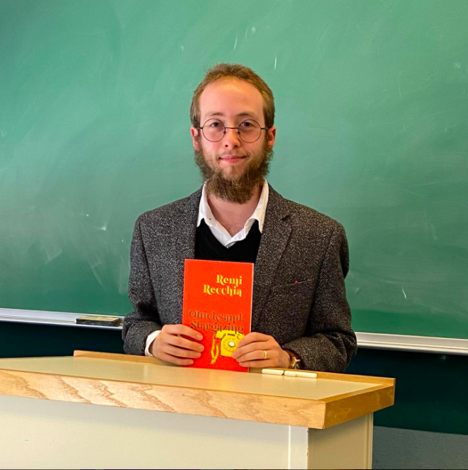 remi recchia, trans poet and essayist, holding book