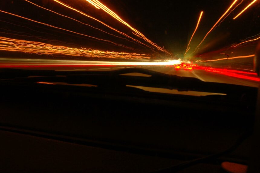 inside dark highway tunnel, taillights and streams of light (from motion)