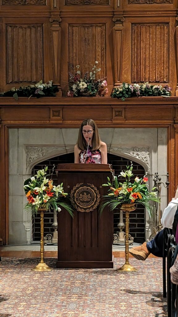 kristine ervin reading at a podium