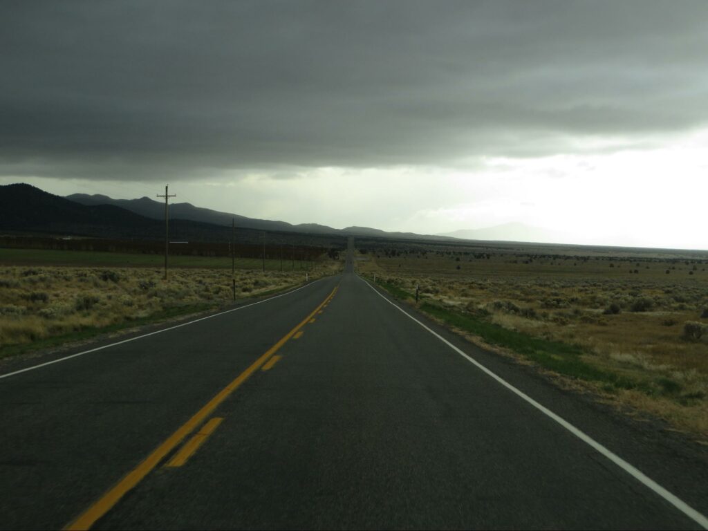 open two-lane highway, rural, at dusk with cloudy skies
