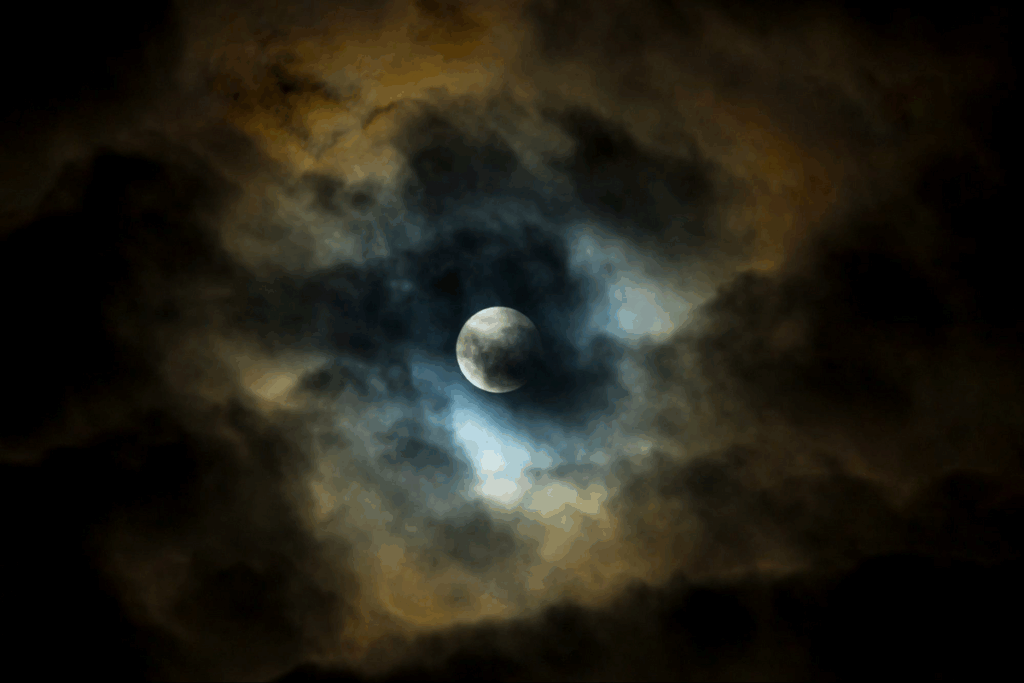 full moon, but partially hidden behind dark clouds