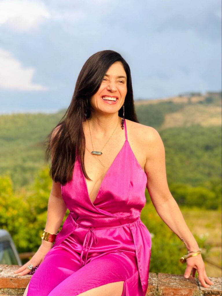 Jennifer Pastiloff in magenta dress with hills and blue sky in back