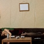 woman asleep on couch by coffee table with empty beer cans