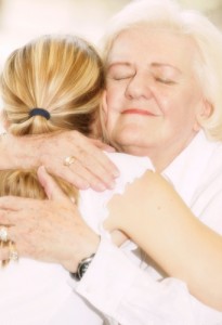 Granmotherly woman hugging young child with ponytail
