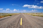 wide angle of empty new mexico road with bright skies and few clouds