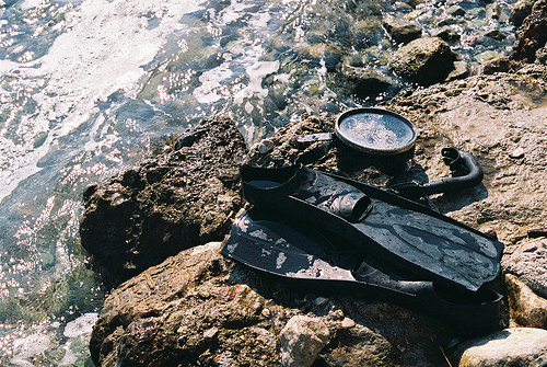 snorkeling gear on rock at shore