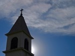 church steeple with cross on top against sky