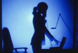 Silhouette of businesswoman standing at desk