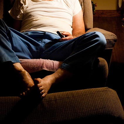 Close up of man sitting in recliner can't see his face - white tee and jeans barefoot