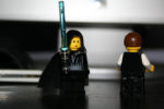luke skywalker lego guy with blue lightsaber next to unknown lego guy