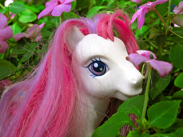 pink my little pony - just head and pink mane showing, against grass and purple flowers