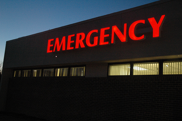 Red lit up emergency sign on hospital exterior