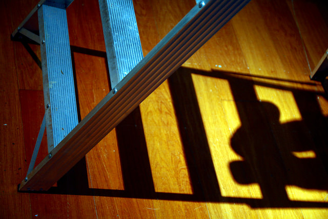 Artistic shot of small ladder with shadow of ladder and feet off to side
