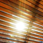 sun shining through closed mini-blinds on window