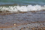 close up of edge of lake michigan, small wave and dirt