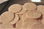 pile of communion wafers - small cross in center