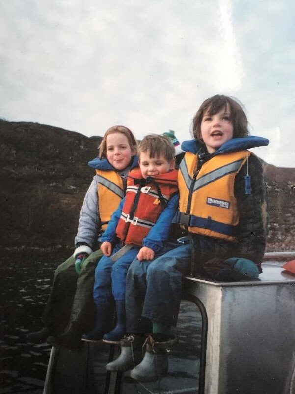 Author and her sister and brother as children sitting down ready to board boat all with life jackets