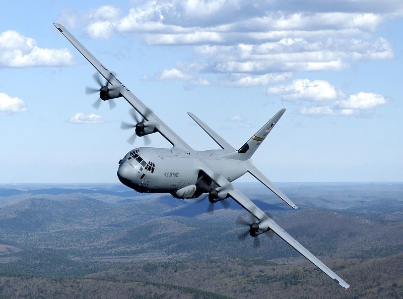 Military airplane in blue sky with stratus clouds turning