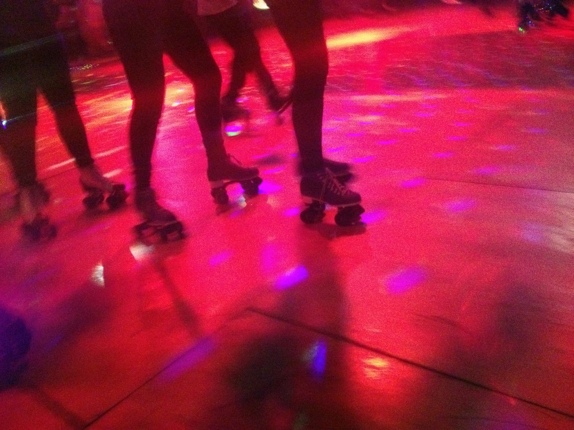 Legs and roller skates on a lit dance floor of a roller disco Shot with an iphone
