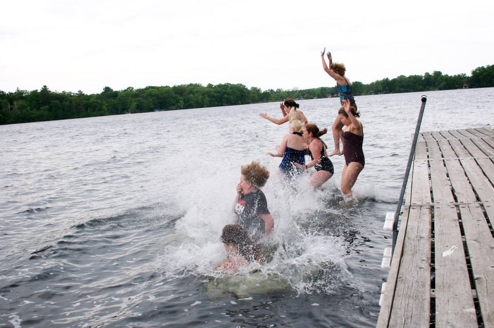 People jumping off a dock into the water