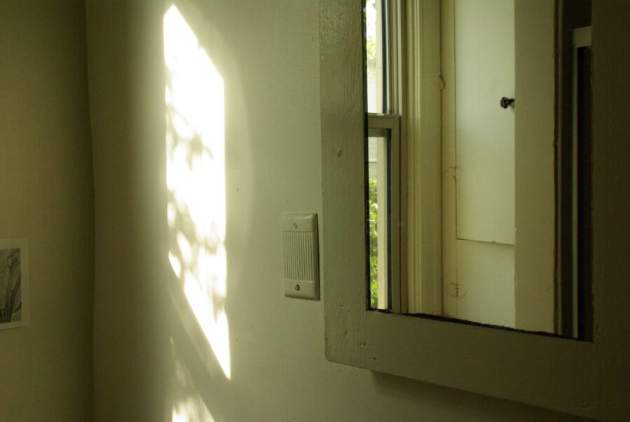 plain white room, looking into mirror to see reflection of door