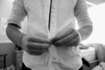 person buttoning a shirt