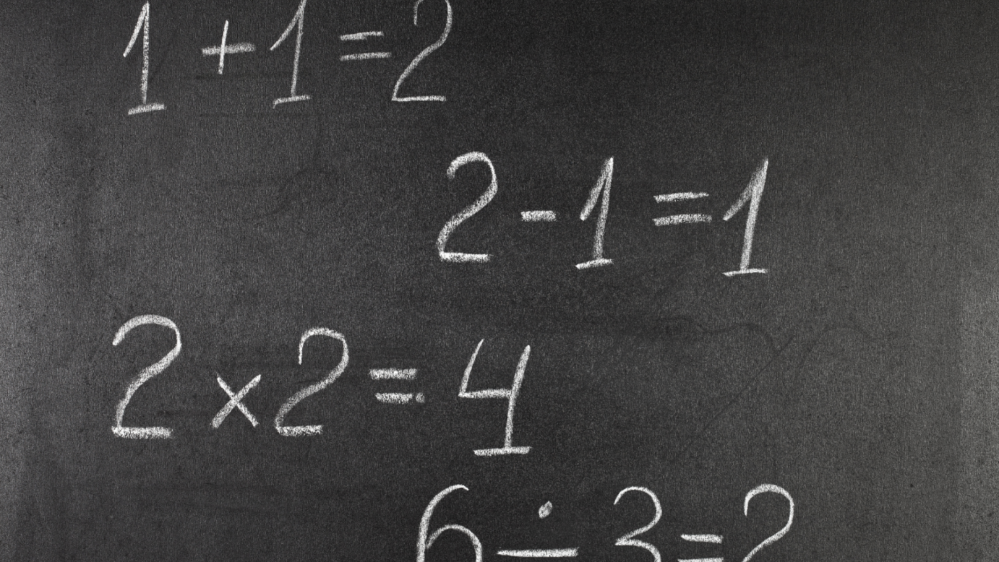 simple math equations in white chalk on a blackboard